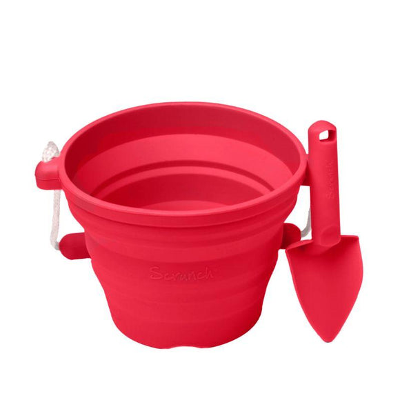 The SCRUNCH Mini Bucket & Spade in Strawberry Red is perfect for little gardeners. Featuring a collapsible silicone bucket with a rope handle and matching shovel, they are designed for easy storage and portability, making them ideal for beach outings or outdoor adventures.