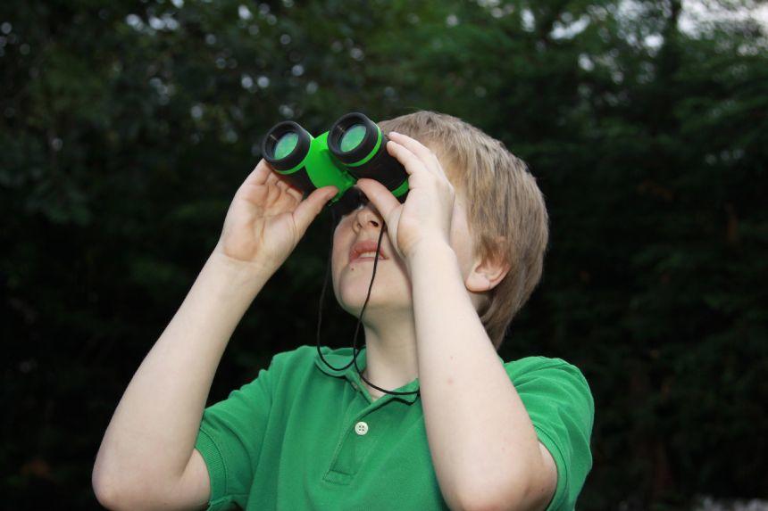 Child outdoors using Brainstorm binoculars.