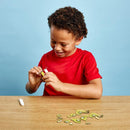 Young boy with dark curly hair and a red tshirt putting the pieces of the Eugy dragon model together.