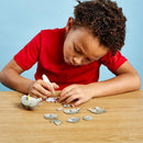 Boy with dark curly hair and red t-shirt stiicking the elephant model pieces together.
