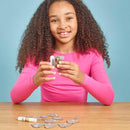 Girl in long sleeved pink t-shirt putting the cardboard parts of the koala figure together.