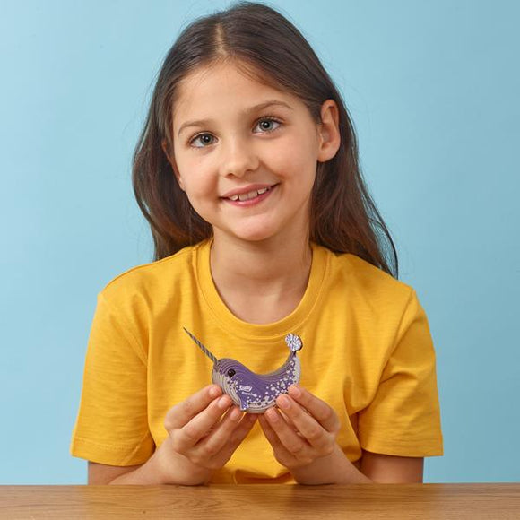 Girl in yellow tshirt holding the purple narwhal model.