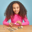Girl in long sleeve pink tshirt putting the sea otter cardboard model together.