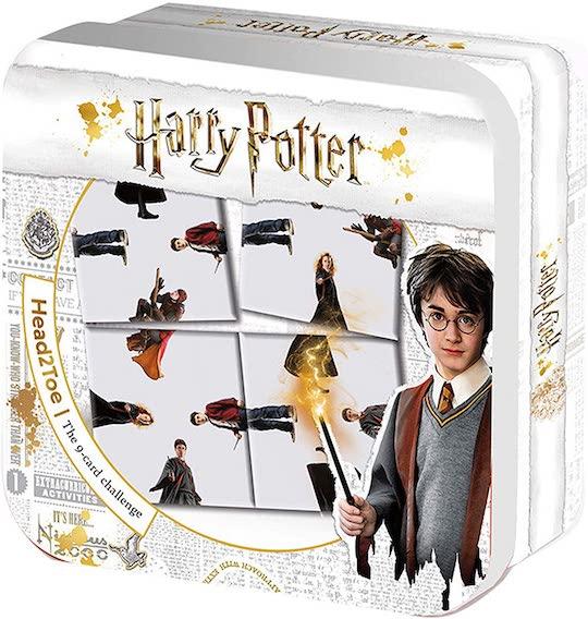 White rectangular tin box with gold coloured decoration containing Harry Potter top to toe card game. There is a picture of Harry Potter in the right corner holding his wand.