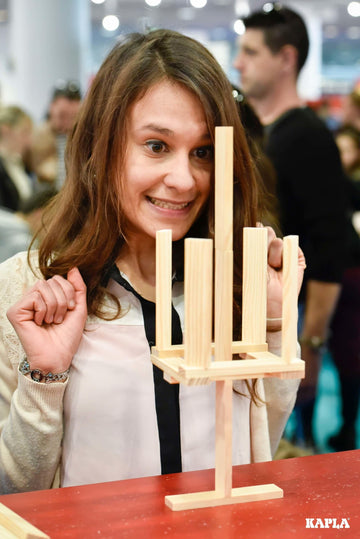 Woman looking happy having completed the build of her Kapla challenge