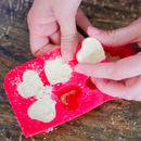 Hands above a wooden table making the bath bombs.