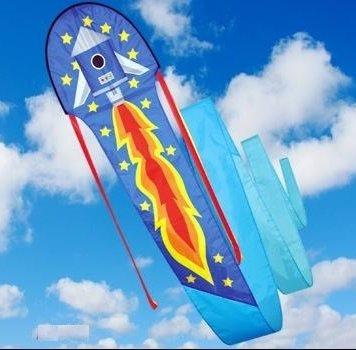 Blue rocket kite with an orange and yellow flame shooting from the bottom with yellow stars round about it and a long blue tail.