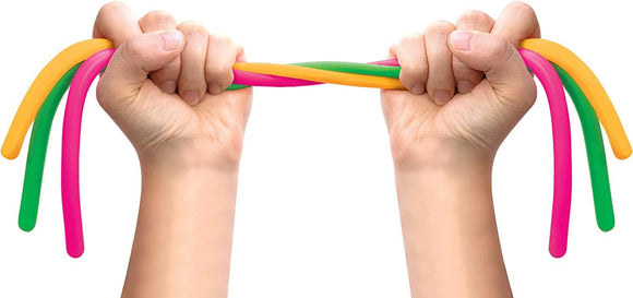 Under the brand Schylling, two hands expertly twist vibrant silicone tubes in shades of pink, orange, and green, highlighting the playful Noodlies fidget toy against a pristine white background.