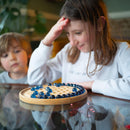 Girl in white top looking perplexed while playing solitaire.