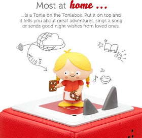 Gretel figure from the Hansel and gretel Tonie. She is wearing a red dresss, yellow hair and standing on top of  a Toniebox.