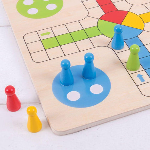 Close up view of one corner of the wooden Ludo board with colourful pieces.
