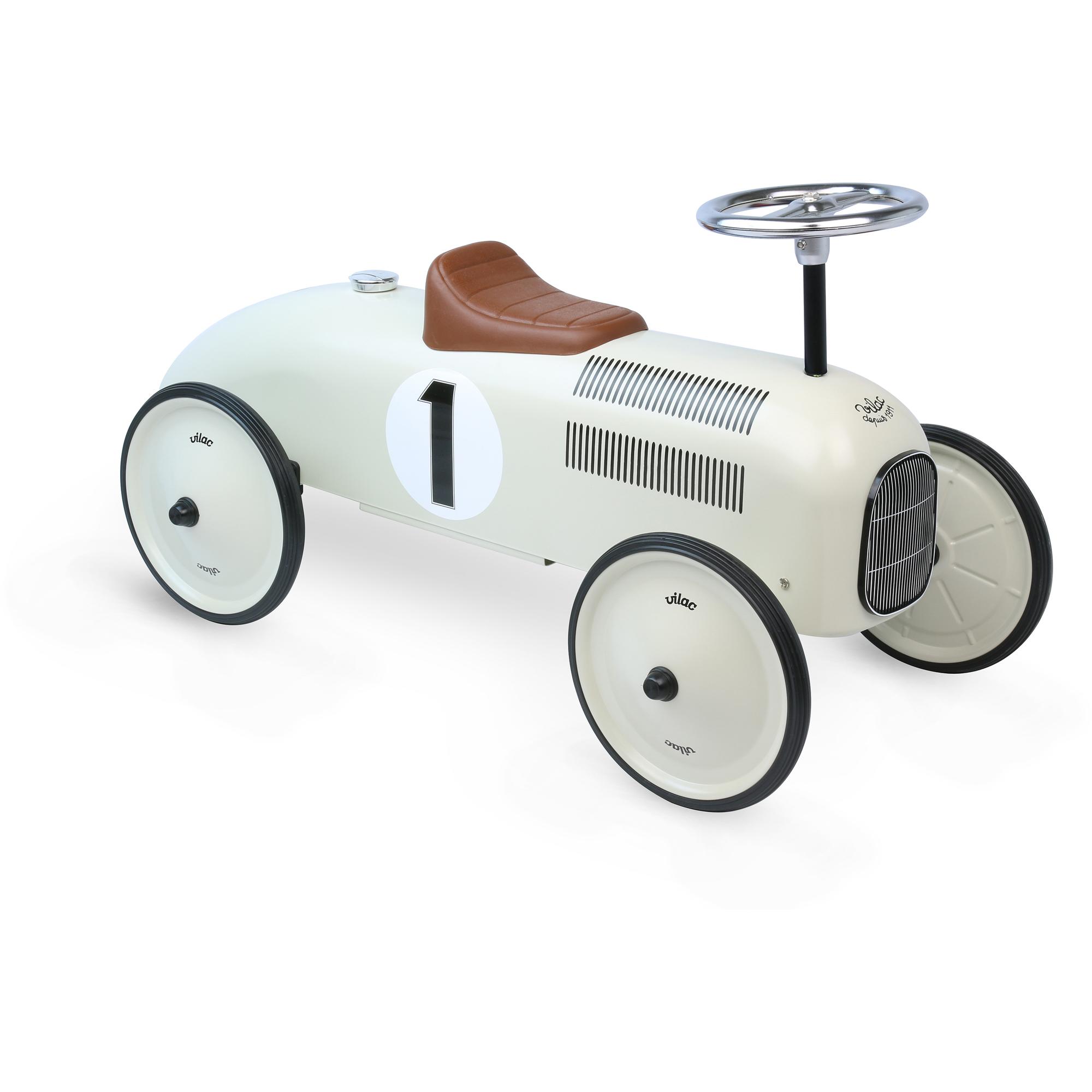 Off-white metal Vilac ride-on car with brown leatherette seat.